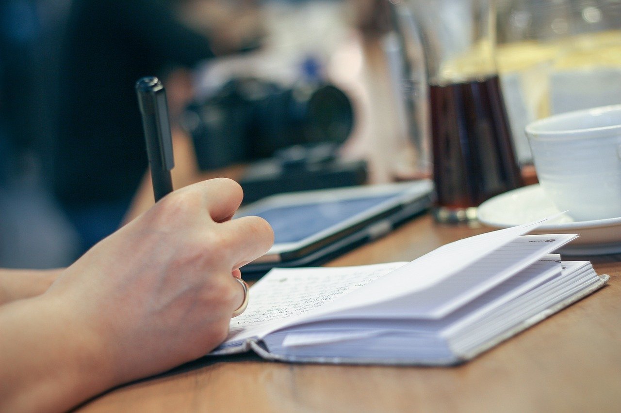 Mano escribiendo en un cuaderno para poner en palabras lo que se siente