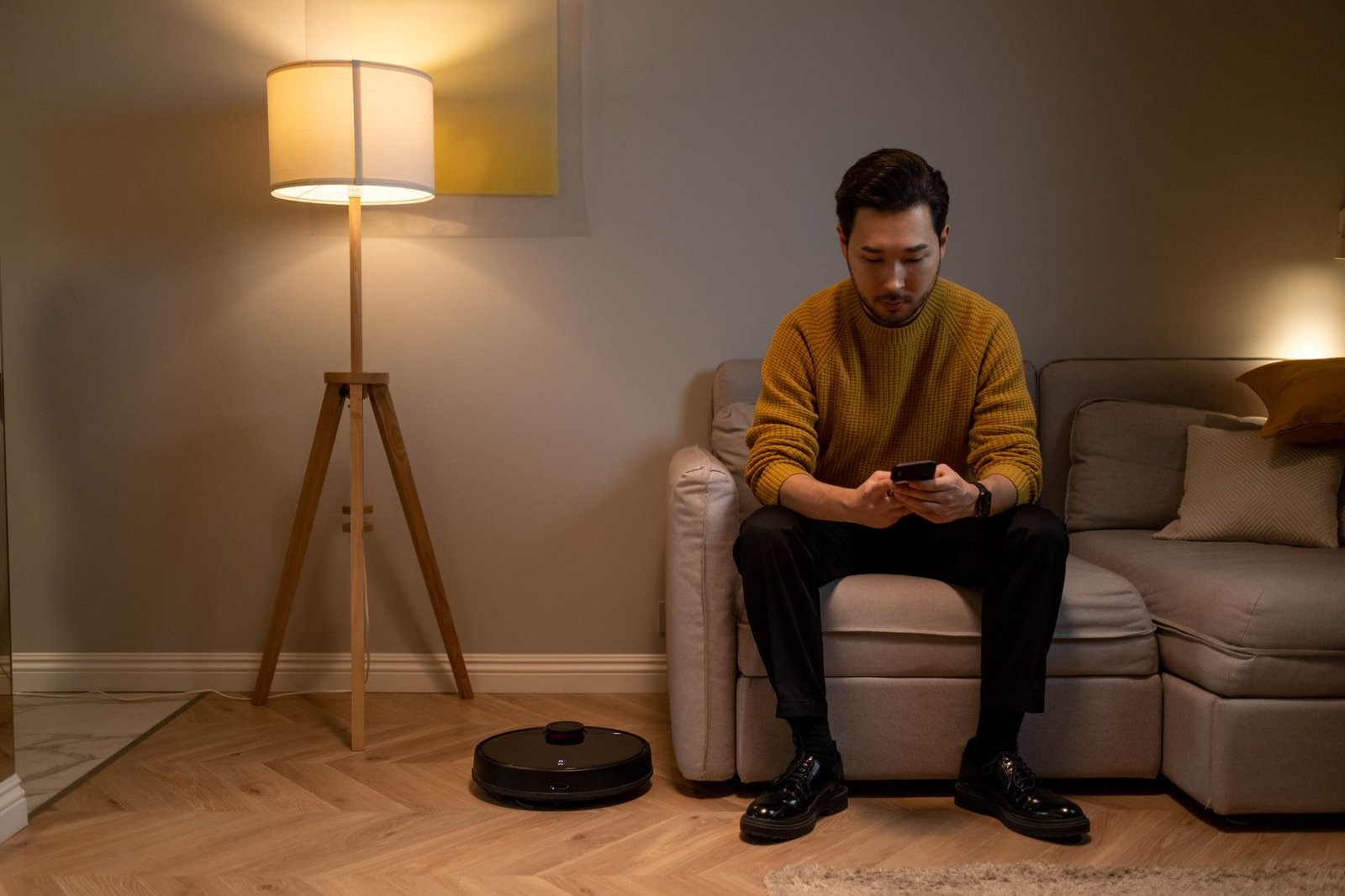 Hombre sentado en el sofá mirando el móvil sin buscar nada, señal de vacío emocional